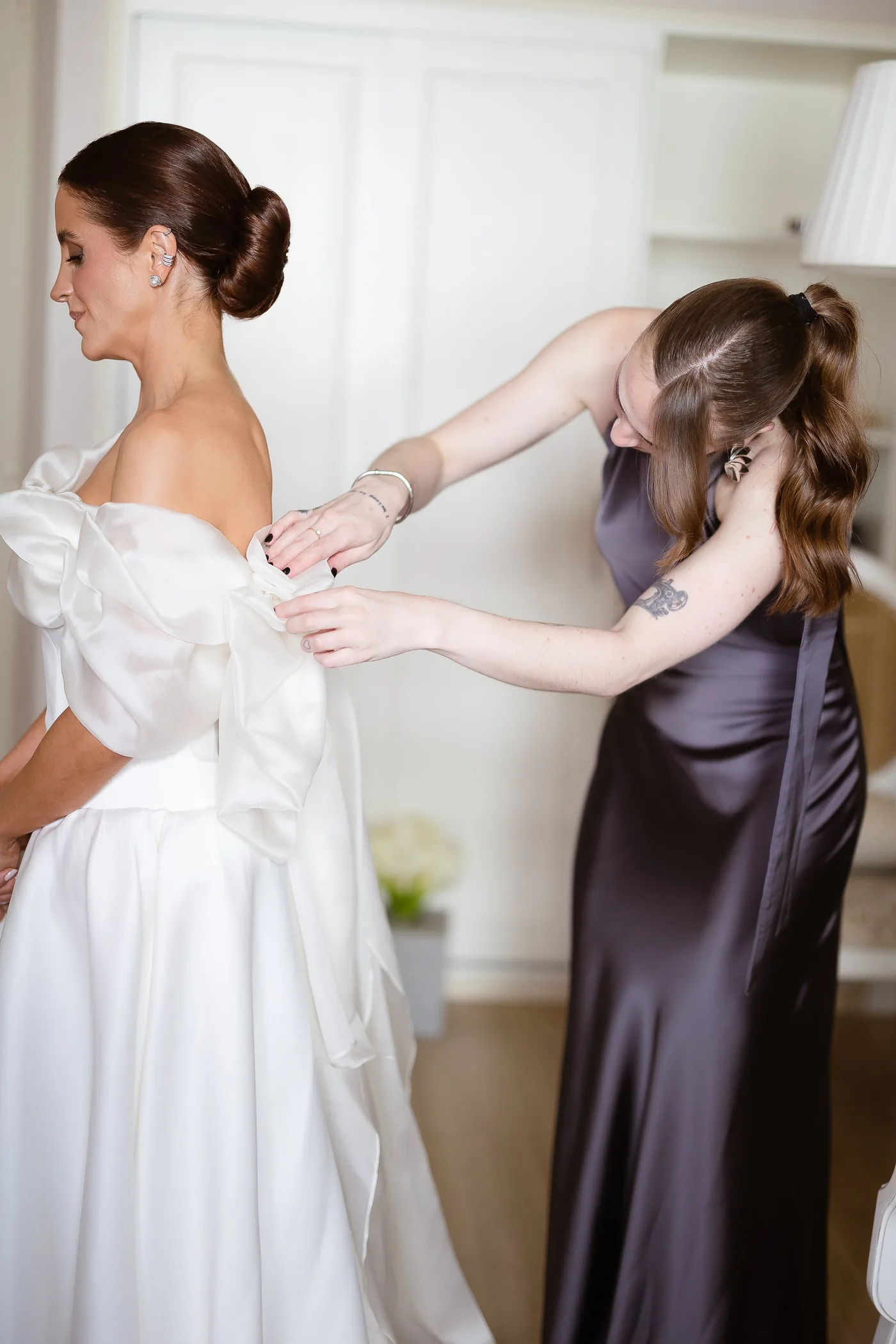 Natália Negri ajustando o vestido da noiva no dia do casamento